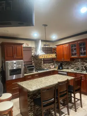 a kitchen with wooden cabinets and a large island with chairs at Elizabeth New Jersey bedroom -Newark Airport -New York City in Elizabeth