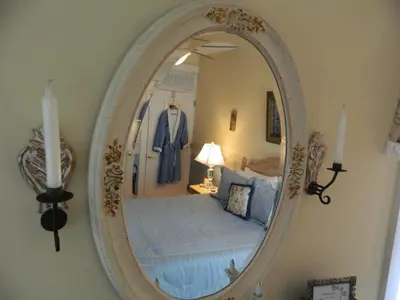 a mirror on a wall with a bed in a room at EJ Bowman House Bed & Breakfast in Lancaster