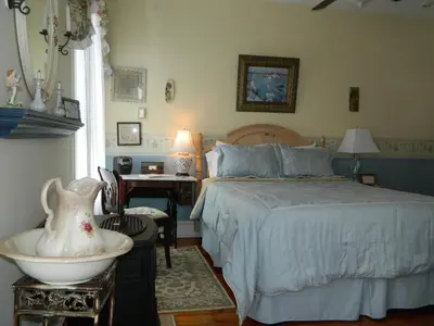 a bedroom with a bed and a desk and a table at EJ Bowman House Bed & Breakfast in Lancaster