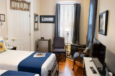 a hotel room with a bed and a desk and chairs at EJ Bowman House Bed & Breakfast in Lancaster