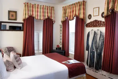 a bedroom with red curtains and a white bed at EJ Bowman House Bed & Breakfast in Lancaster