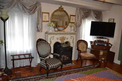 a living room with a fireplace with chairs and a television at EJ Bowman House Bed & Breakfast in Lancaster