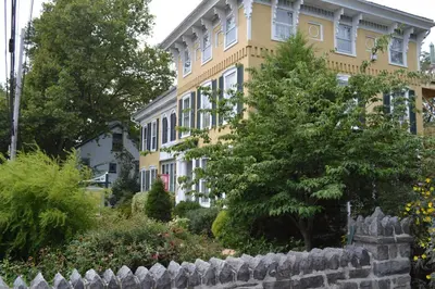 a yellow house with a fence in front of it at EJ Bowman House Bed & Breakfast in Lancaster