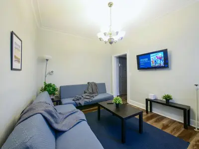 a living room with a blue couch and a tv at Charming 1BR Apartment Near NYC Ideal for Urban Explorers in Jersey City