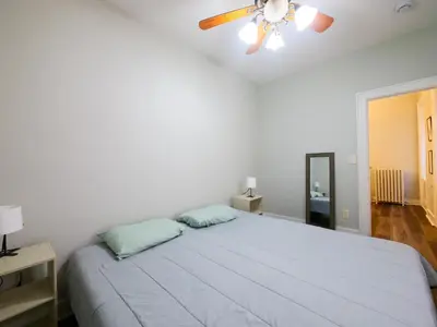 a bedroom with a bed with a ceiling fan at Charming 1BR Apartment Near NYC Ideal for Urban Explorers in Jersey City