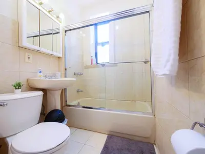 a bathroom with a shower and a toilet and a sink at Charming 1BR Apartment Near NYC Ideal for Urban Explorers in Jersey City