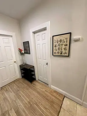 a room with a white door and a vase of flowers at Cozy 3 BR suite, 15 min to NYC &Times Sq in North Bergen