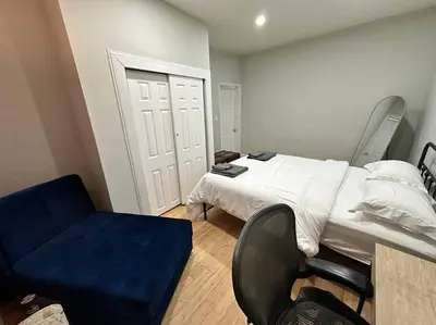 a bedroom with a bed and a blue chair at Cozy 3 BR suite, 15 min to NYC &Times Sq in North Bergen