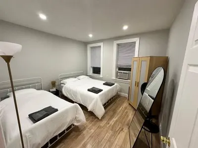 a hotel room with two beds and a mirror at Cozy 3 BR suite, 15 min to NYC &Times Sq in North Bergen