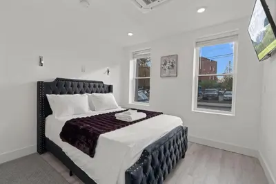 a bedroom with a large bed with a black headboard at New Season Royals, Airport West in Chester