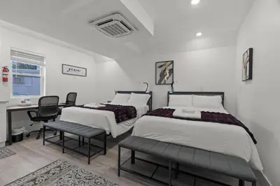 two beds in a room with a desk and chairs at New Season Royals, Airport West in Chester