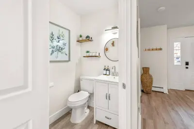 a white bathroom with a toilet and a sink at Boho Haven Hideaway - Walk to Pool,Theater,Arcades, Firepit, Lake Access in Thornhurst