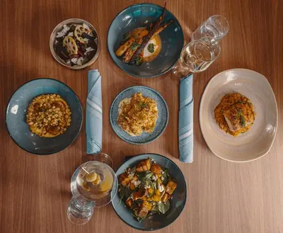 a wooden table with plates of food and wine glasses at Hotel Indigo West Chester - Downtown by IHG in West Chester