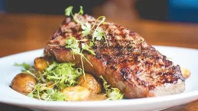 a plate of food with a piece of meat and vegetables at Hotel Indigo West Chester - Downtown by IHG in West Chester