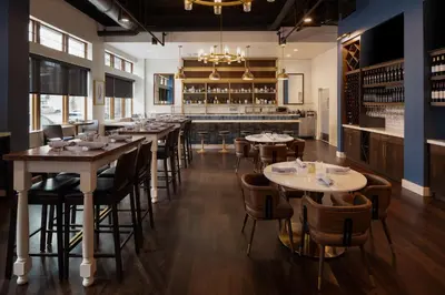 a restaurant with tables and chairs and a bar at Hotel Indigo West Chester - Downtown by IHG in West Chester