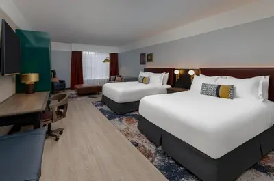 a hotel room with two beds and a desk at Hotel Indigo West Chester - Downtown by IHG in West Chester