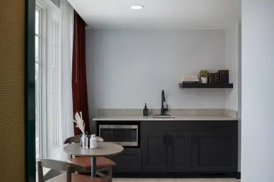 a kitchen with black cabinets and a small table at Hotel Indigo West Chester - Downtown by IHG in West Chester