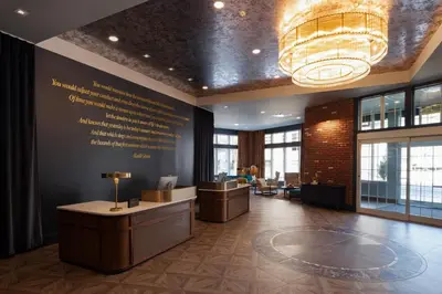 a lobby with a reception desk and a chandelier at Hotel Indigo West Chester - Downtown by IHG in West Chester