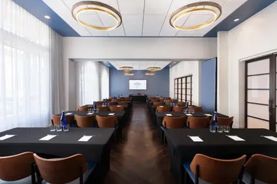 a room with rows of tables and chairs at Hotel Indigo West Chester - Downtown by IHG in West Chester