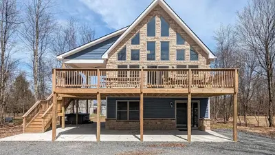 a house with a large deck on a lot at Bluejay Getaway by AvantStay Private Lake Cabin • Hot Tub Game Room Walk to Lake in Albrightsville