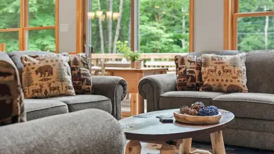 a living room with couches and a table with a bowl of fruit at Bluejay Getaway by AvantStay Private Lake Cabin • Hot Tub Game Room Walk to Lake in Albrightsville