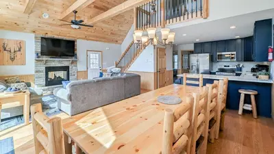 a kitchen and living room with a wooden table and a couch at Bluejay Getaway by AvantStay Private Lake Cabin • Hot Tub Game Room Walk to Lake in Albrightsville