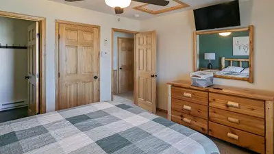 a bedroom with a bed and a dresser and a mirror at Bluejay Getaway by AvantStay Private Lake Cabin • Hot Tub Game Room Walk to Lake in Albrightsville
