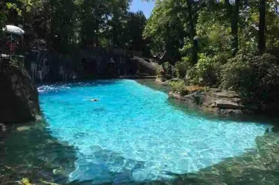 a pool of blue water with trees in the background at 10 guest Ski Chalet Pools Golf Ski Hike in Vernon Township