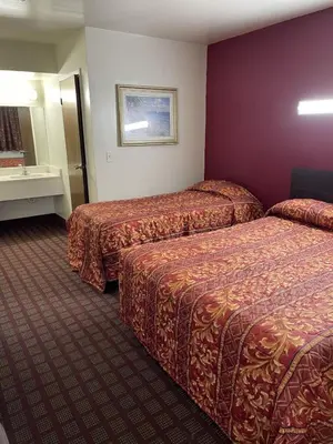 a hotel room with two beds and a mirror at Budget Inn - Elizabeth, NJ in Elizabeth