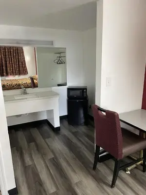 a room with a desk and a table and a chair at Budget Inn - Elizabeth, NJ in Elizabeth
