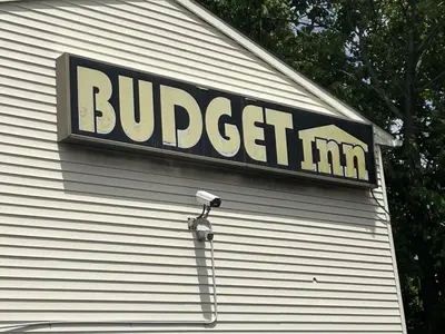 a sign on the side of a building with a camera at Budget Inn - Elizabeth, NJ in Elizabeth
