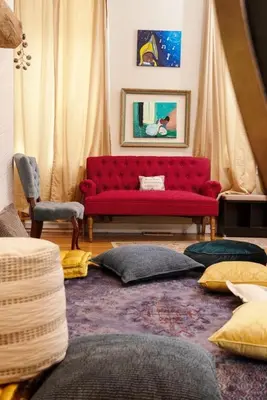 a red couch in a living room with pillows at MASSiVE Bohemian Oasis in Philly 5 Bdrm Sleeps 12 in Philadelphia