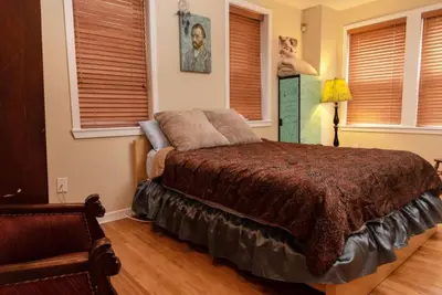 a bedroom with a bed in a room with windows at MASSiVE Bohemian Oasis in Philly 5 Bdrm Sleeps 12 in Philadelphia
