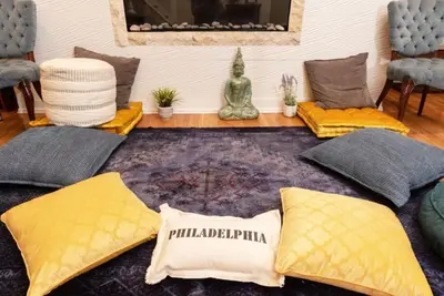 a living room with yellow pillows and a rug at MASSiVE Bohemian Oasis in Philly 5 Bdrm Sleeps 12 in Philadelphia