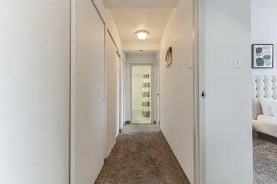 a hallway with white walls and a hallway with a white couch at PP 1009 Beautiful Corporate 2br Apt, Pool in Harrisburg