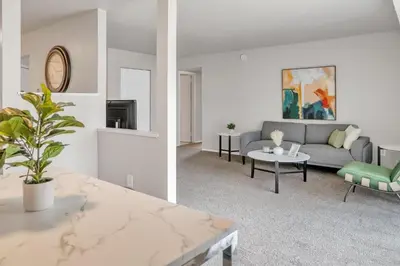a living room with a couch and a table at Spacious Retreat I Balcony I Parking I Chateau in Wilmington