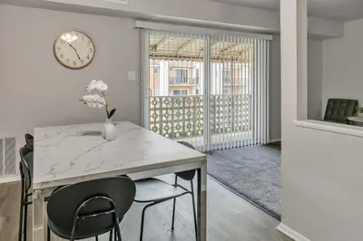 a dining room with a table and chairs and a clock at Luxurious 2-bedroom Apartment In Wilmington in Wilmington