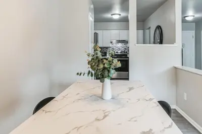 a white marble table with a vase of flowers on it at Chateau 506 Stunning In Wilmington, Free Parking! in Wilmington