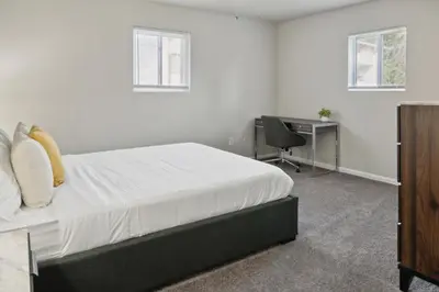 a bedroom with a bed and a desk and a chair at Historic Charm Meets Modern Comfort The Chateau in Wilmington