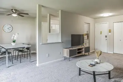 a living room with a tv and a table at Historic Charm Meets Modern Comfort The Chateau in Wilmington
