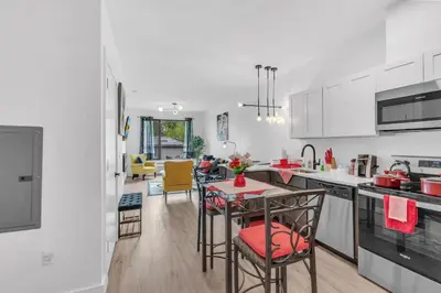 a kitchen with white cabinets and a table and chairs at Royal Oasis Indoor Pool, FREE Parking, Near NYC in Elizabeth