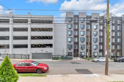a red car parked in front of a building at Royal Oasis Indoor Pool, FREE Parking, Near NYC in Elizabeth