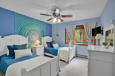 a blue bedroom with two beds and a ceiling fan at Lakefront Family Home, Kayaks, Hot Tub, Fireplace in Lake Ariel