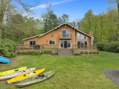 a group of kayaks parked in front of a house at Lakefront Family Home, Kayaks, Hot Tub, Fireplace in Lake Ariel