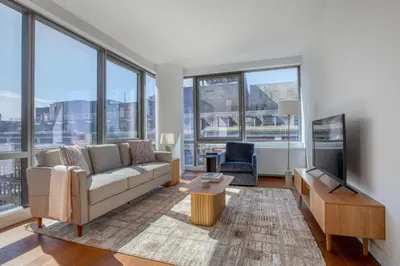 a living room with a couch and a tv at Blueground Hudson Yards gym rock wall arcade NYC-1453 in New York