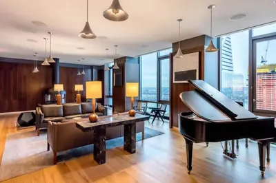 a living room with a piano and a couch at Blueground Hudson Yards gym rock wall arcade NYC-1453 in New York