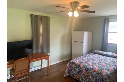 a bedroom with a bed and a desk and a ceiling fan at Werry's Cottages and Pub By OYO East Stroudsborg - Weekly Stays in East Stroudsburg