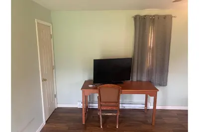 a desk with a television and a chair in a room at Werry's Cottages and Pub By OYO East Stroudsborg - Weekly Stays in East Stroudsburg