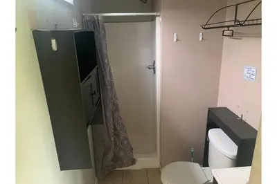 a bathroom with a shower curtain and a toilet at Werry's Cottages and Pub By OYO East Stroudsborg - Weekly Stays in East Stroudsburg