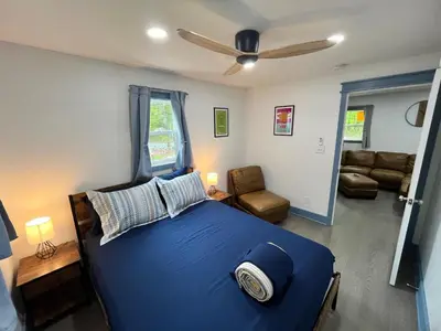 a bedroom with a blue bed and a living room at Bear Run Bungalow in Hawley